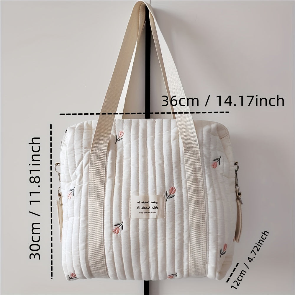 Cotton embroidered and quilted mommy handbag with trolley and hanging feature. Includes diaper bag, bottle finishing bag, and multifunctional mother bag. Zipper style closure. Measures 36x30x12CM.