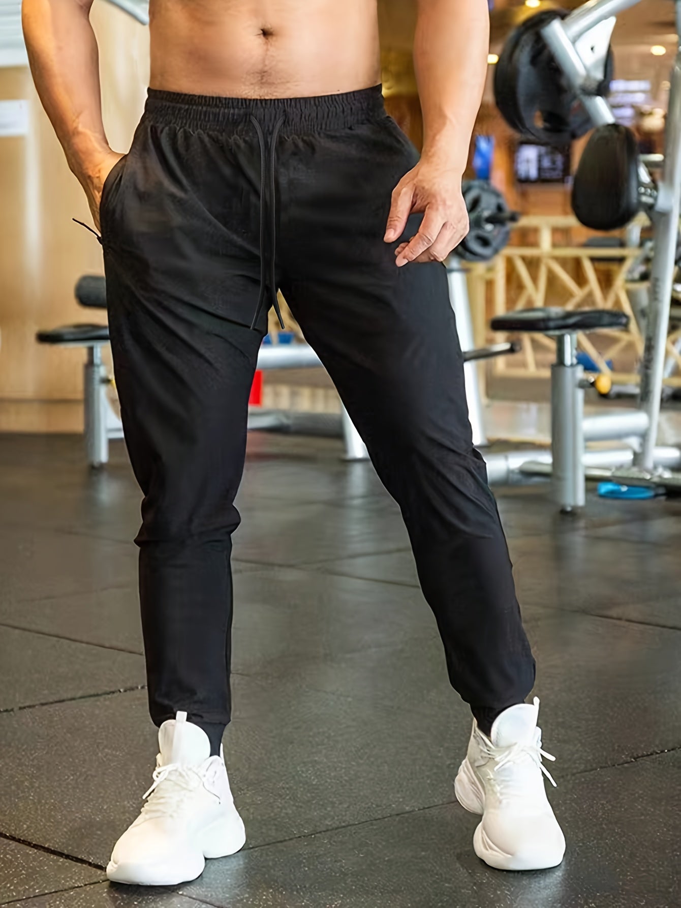 Men's athletic joggers in black made of breathable polyester with an elastic waistband and drawstring; suitable for gym, running, and casual wear.