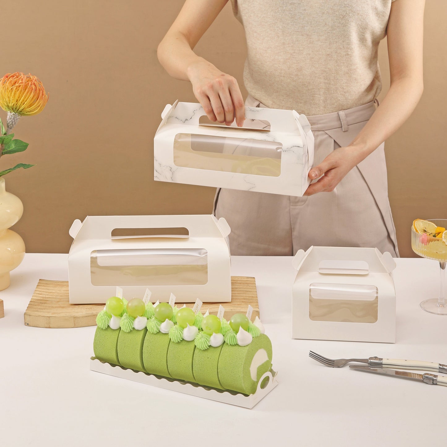 Get 5 or 10 pieces of portable cake boxes in 2 sizes, featuring a window to display your treats. These white paper cardboard bakery boxes are perfect for Swiss rolls, pastries, cupcakes, muffins, cookies, pies, and more. Use them for gift wrapping or as