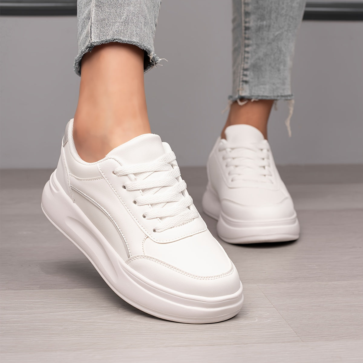 Women's white skate shoes with round toe, lace up closure, and low top flat design. Comfortable for casual wear and sports.