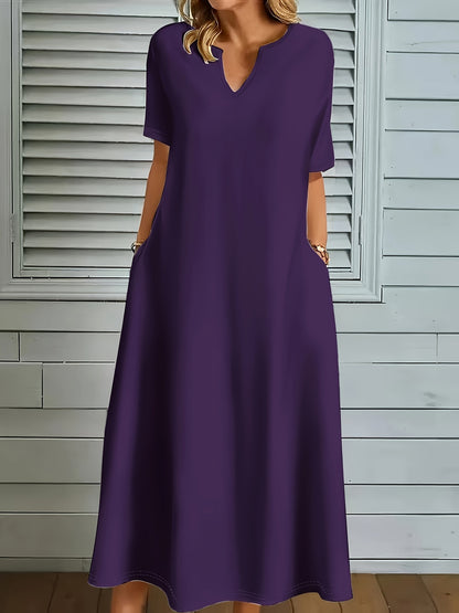 Plus size V-neck dress in solid color polyester knit with long flared hem. Medium stretch, pullover style with pocket detail for casual fall/winter wear.