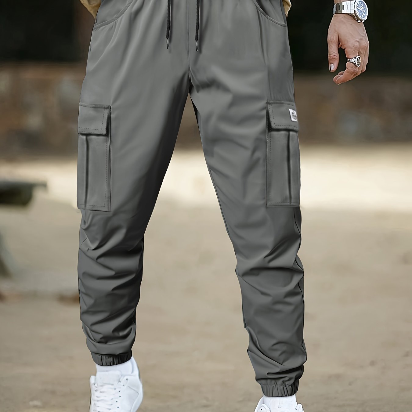 Men's camo cargo pants made from 100% non-stretch polyester fabric with a drawstring waist and flap pockets. Suitable for outdoor work.