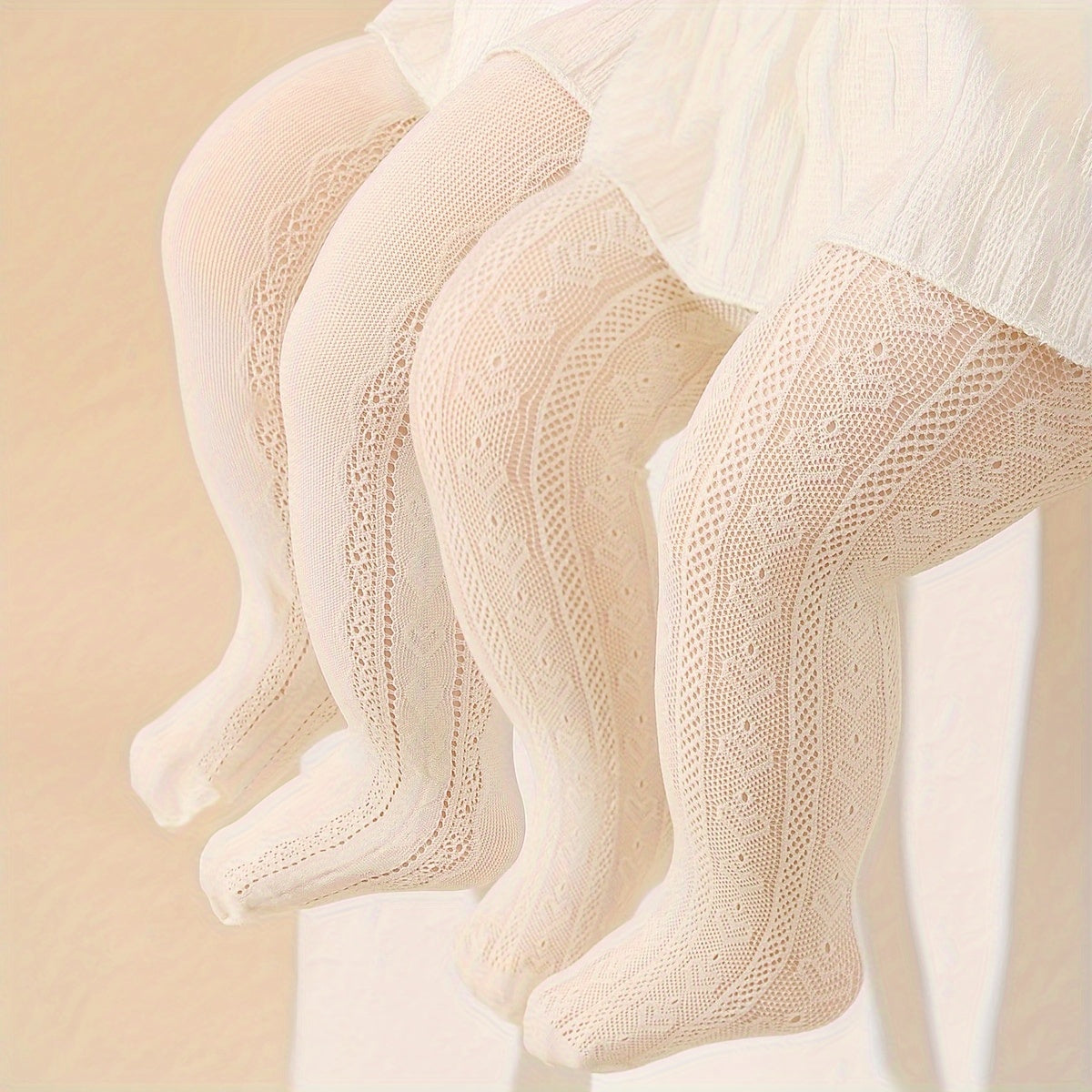 Two pairs of girls' white and beige princess-style tights with heart pattern and breathable comfort.