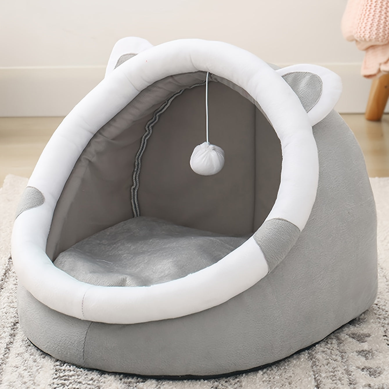 Convertible grey cat ear pet bed made of polyester fiber material. Suitable for small to medium cats and dogs. All-season indoor sleeping lounge with dangling ball toy.