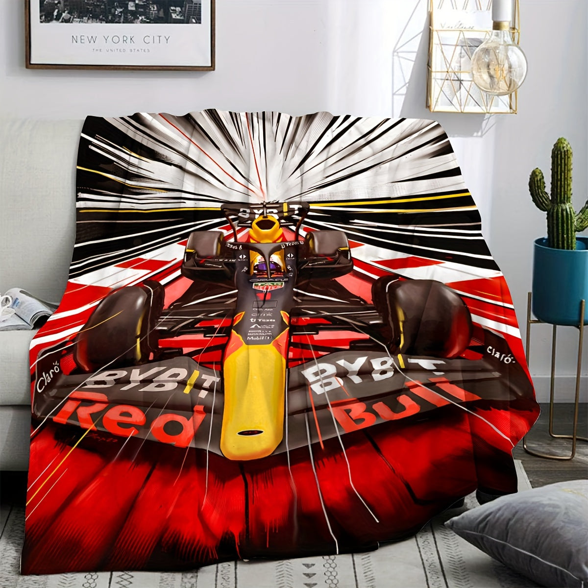 Soft and skin-friendly, this all-season cozy sofa and nap blanket features a dynamic digital design of a vibrant Formula 1 racing car. The blanket is made of flannel and is in red and black with yellow accents.