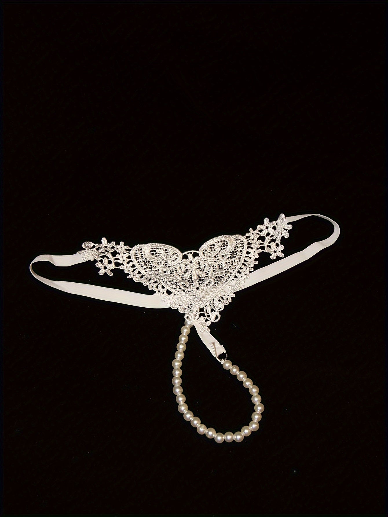 Low-rise thong with pearl embellishments and hollow out design. Breathable polyester, hand washable. Ideal for adults.