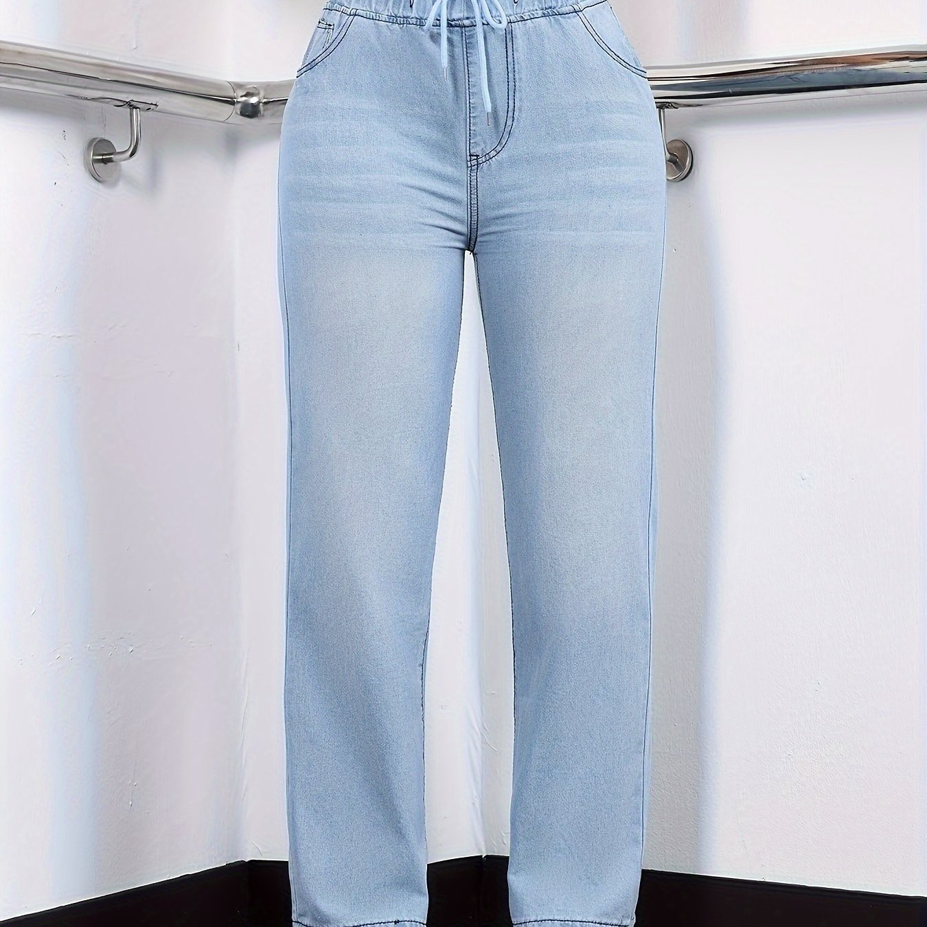 Women's stylish washed blue jeans with elastic waistband, made from comfortable polyester blend denim, suitable for all seasons.