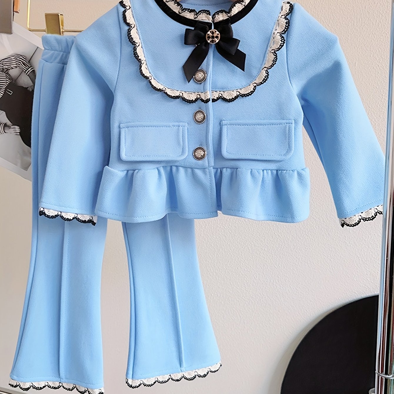 Stylish 2-piece girl's outfit includes frilled cardigan top and flared trousers for outdoor activities in spring/fall.