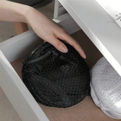 Large pop-up laundry basket with handle and foldable design, ideal for high-capacity dirty clothes storage. Black fabric with modern round shape, perfect for home organization in the kitchen.