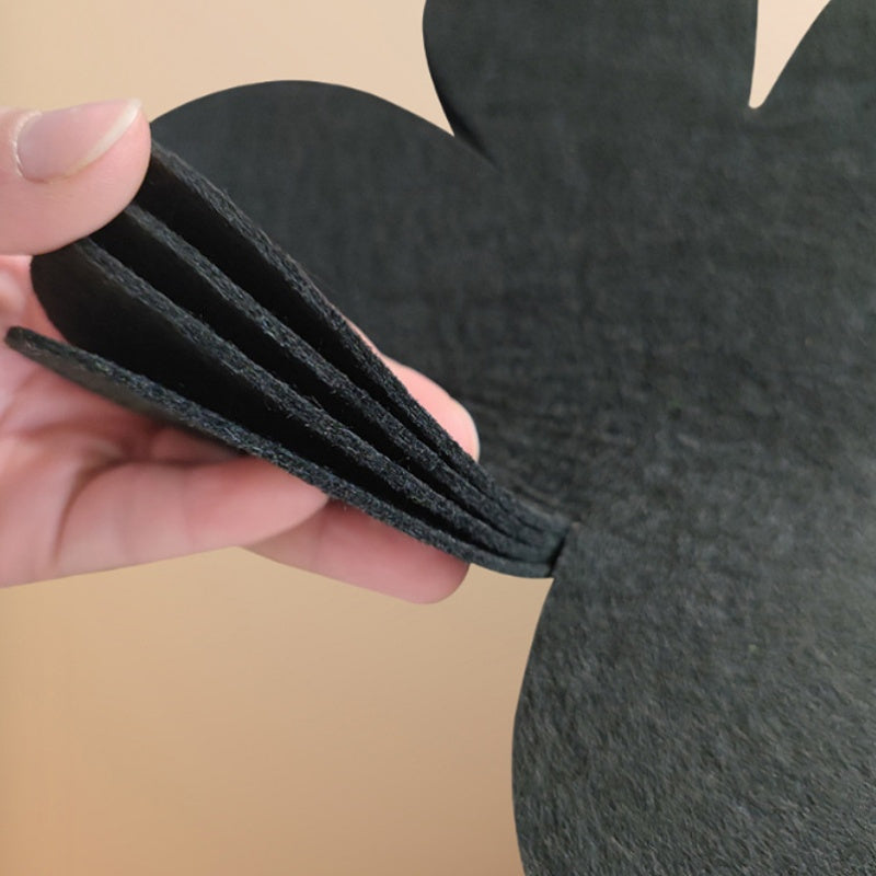 Set of 4 black petal-shaped pan pads made of non-woven, non-stick material. These pads are non-slip, anti-scalding, and provide heat insulation. They are easy to clean and made of multi-ply felt cloth.