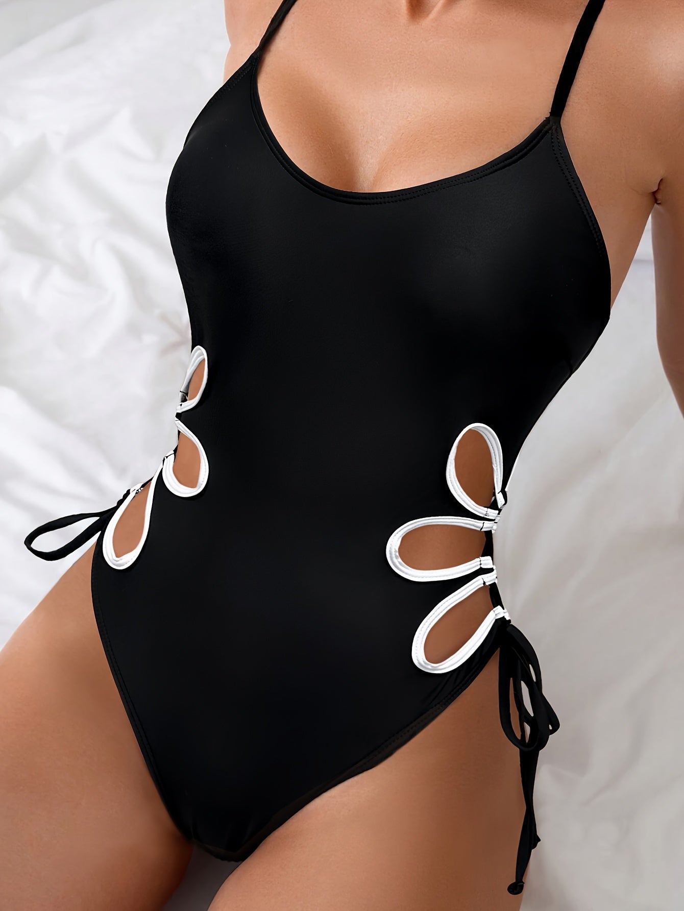 Black swimsuit with white edges, designed for women for beach outings.