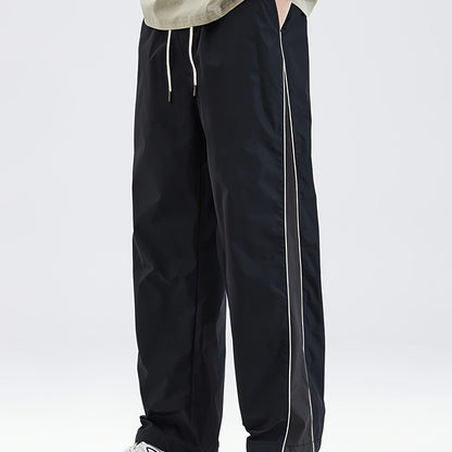 Men's black lightweight joggers with drawstring waist, perfect for spring and fall. Made of polyester fabric with a loose fit and glossy finish.