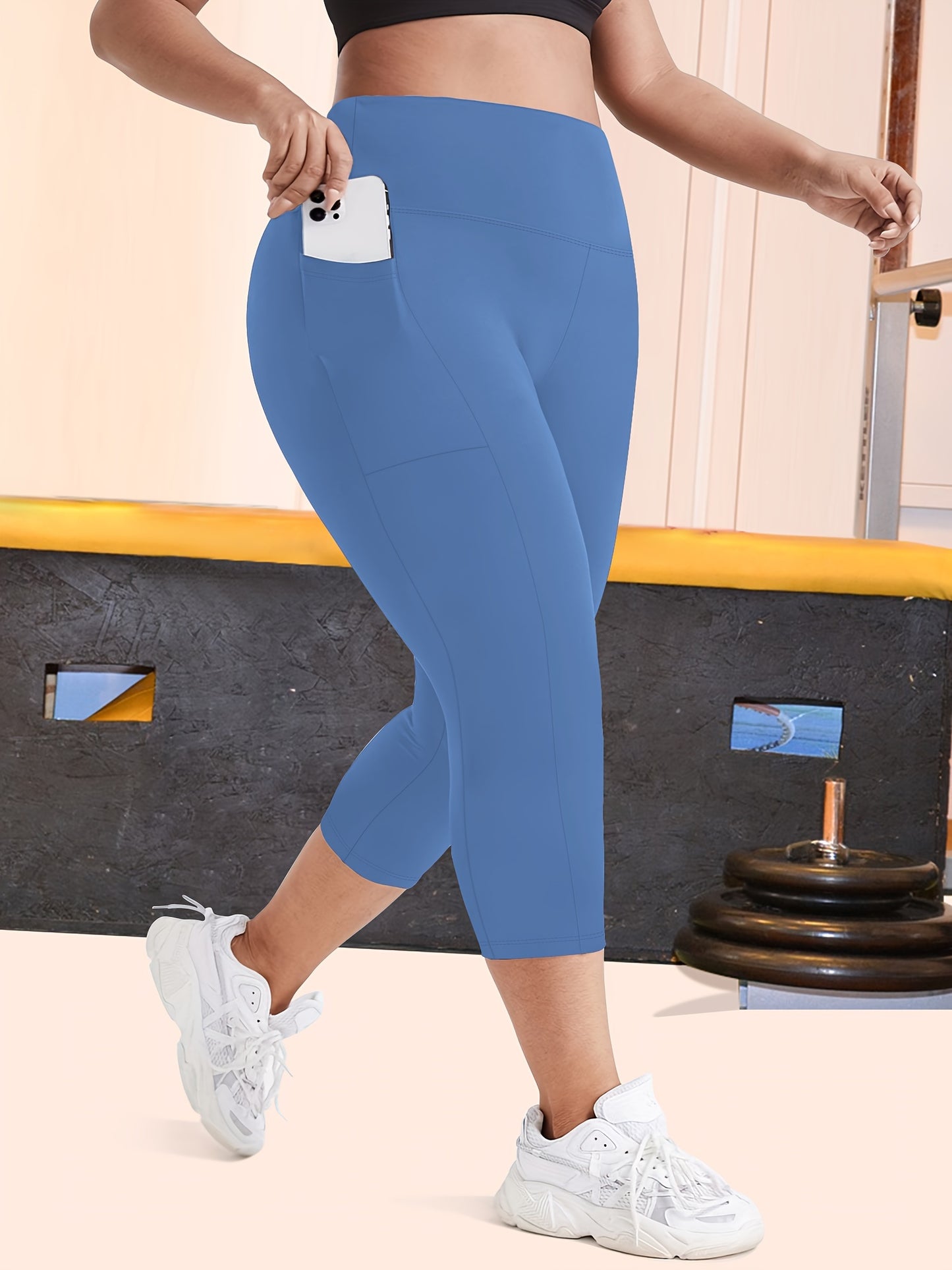 High-waisted capri leggings for plus-size women with side phone pockets, ideal for workouts.