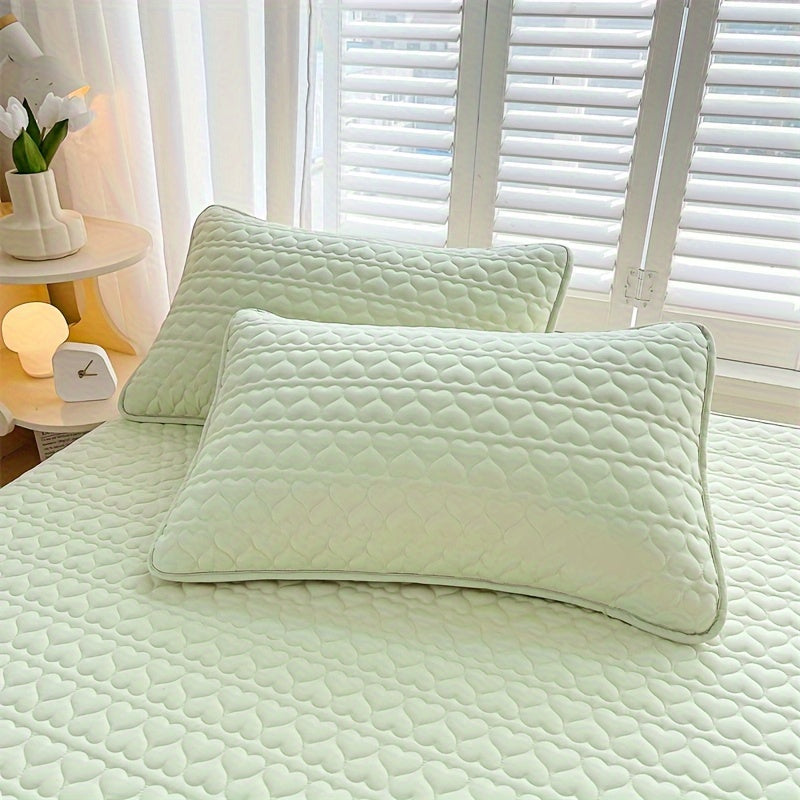 Two quilted pillowcases with waterproof lining, designed to be thick, oil-resistant, and machine washable in a stylish white and light gray color. Featuring an envelope closure, these pillowcases measure 48.26x76.2 cm and are perfect for home, hotel, or