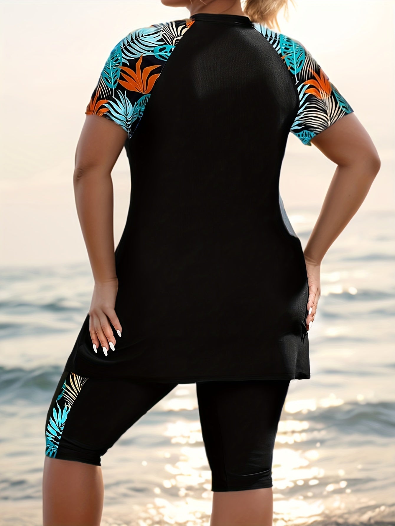 Tropical print swimsuit set for plus size women, made of stretchy polyester and elastane. Features round neck top with short sleeves and high-waist bottoms. Machine washable.