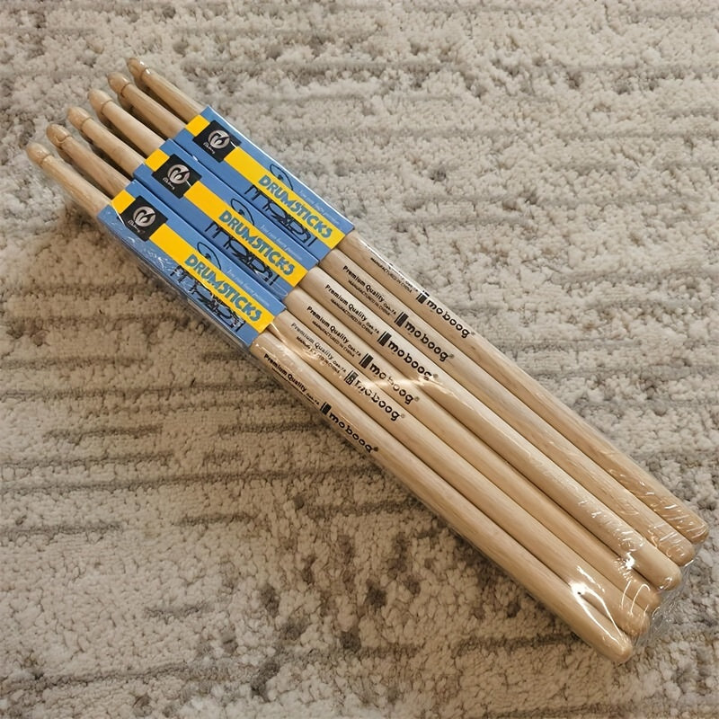 Set of 12 pairs of 5A/7A oak drumsticks for percussion instruments, jazz drumming, and electronic drums. Premium wood grain design for beginners and professional drummers. Labeled as