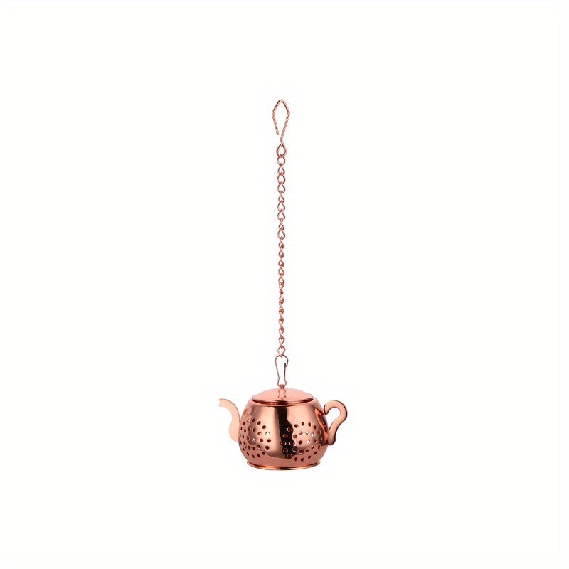 Golden rose stainless steel teapot-shaped tea strainer with uniform filter holes and hanging chain for cups.