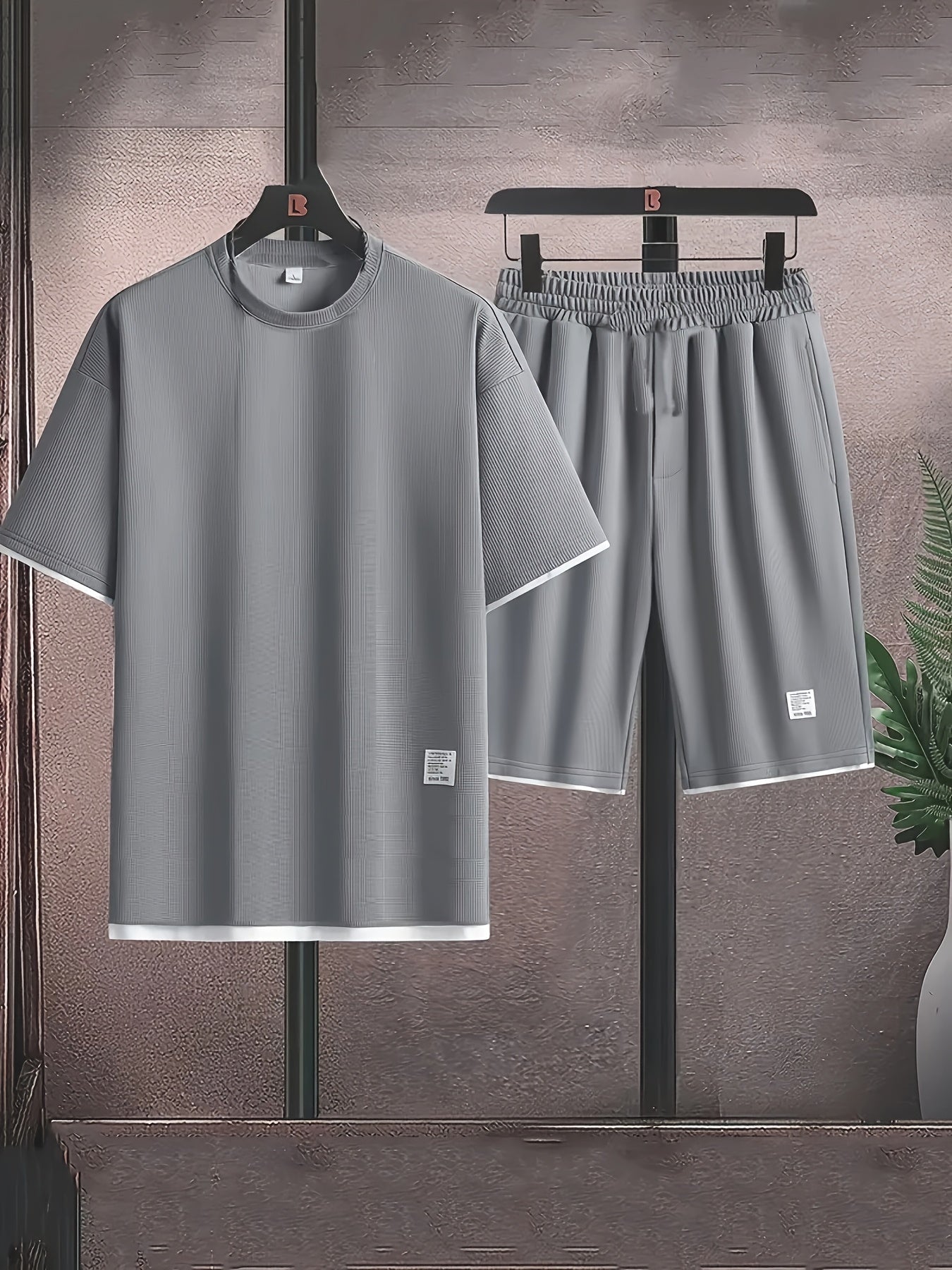 Men's casual waffle knit pajama set in gray and black with short sleeve top and elastic waist shorts. Features applique detailing and soft polyester fabric for comfort.