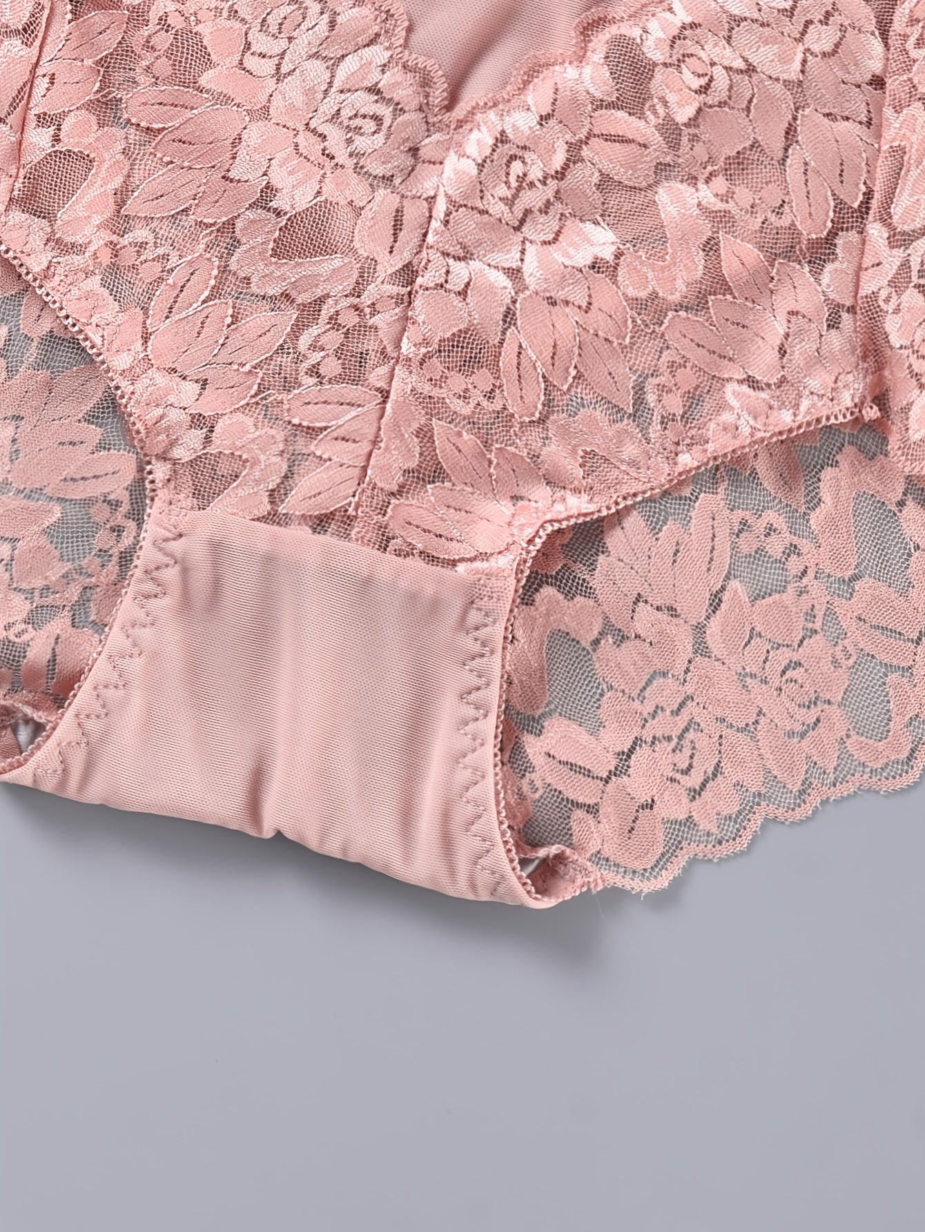 Two-pack plus-size lace panties for women made of 90% polyamide and 10% elastane. Features a medium-stretch knit fabric with a hollow floral pattern. Breathable, comfortable, and embodies a