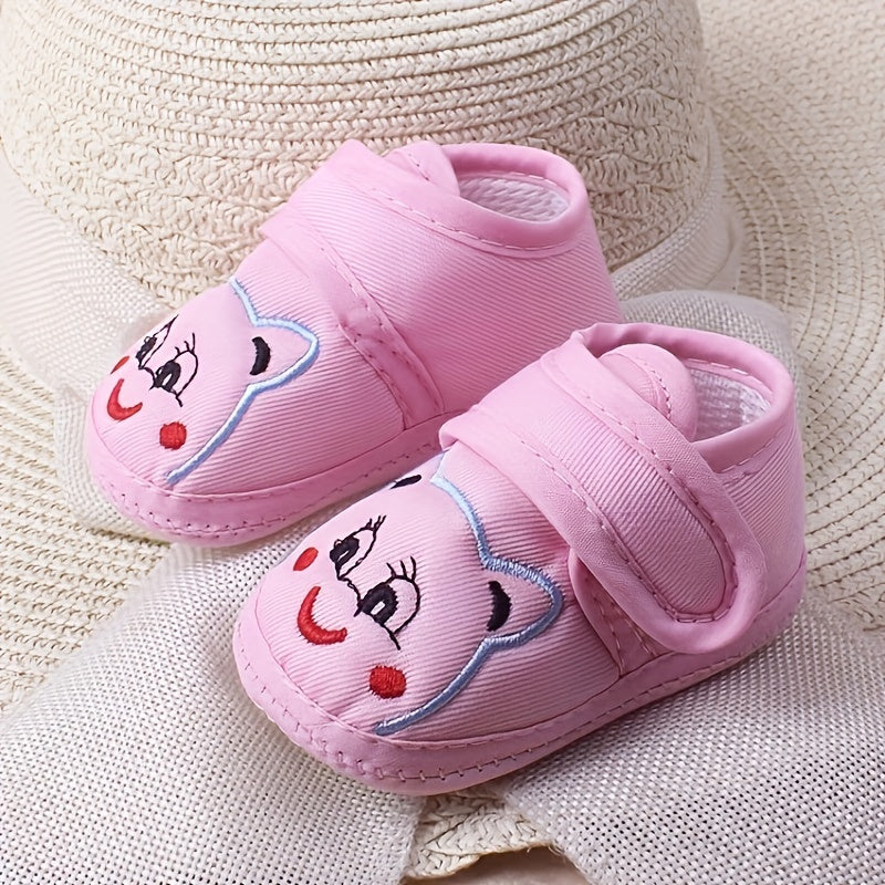 Cute baby walking shoes for boys and girls in light blue with cartoon faces, non-slip soles, and hook-and-loop closure. Ideal for first steps in any season.