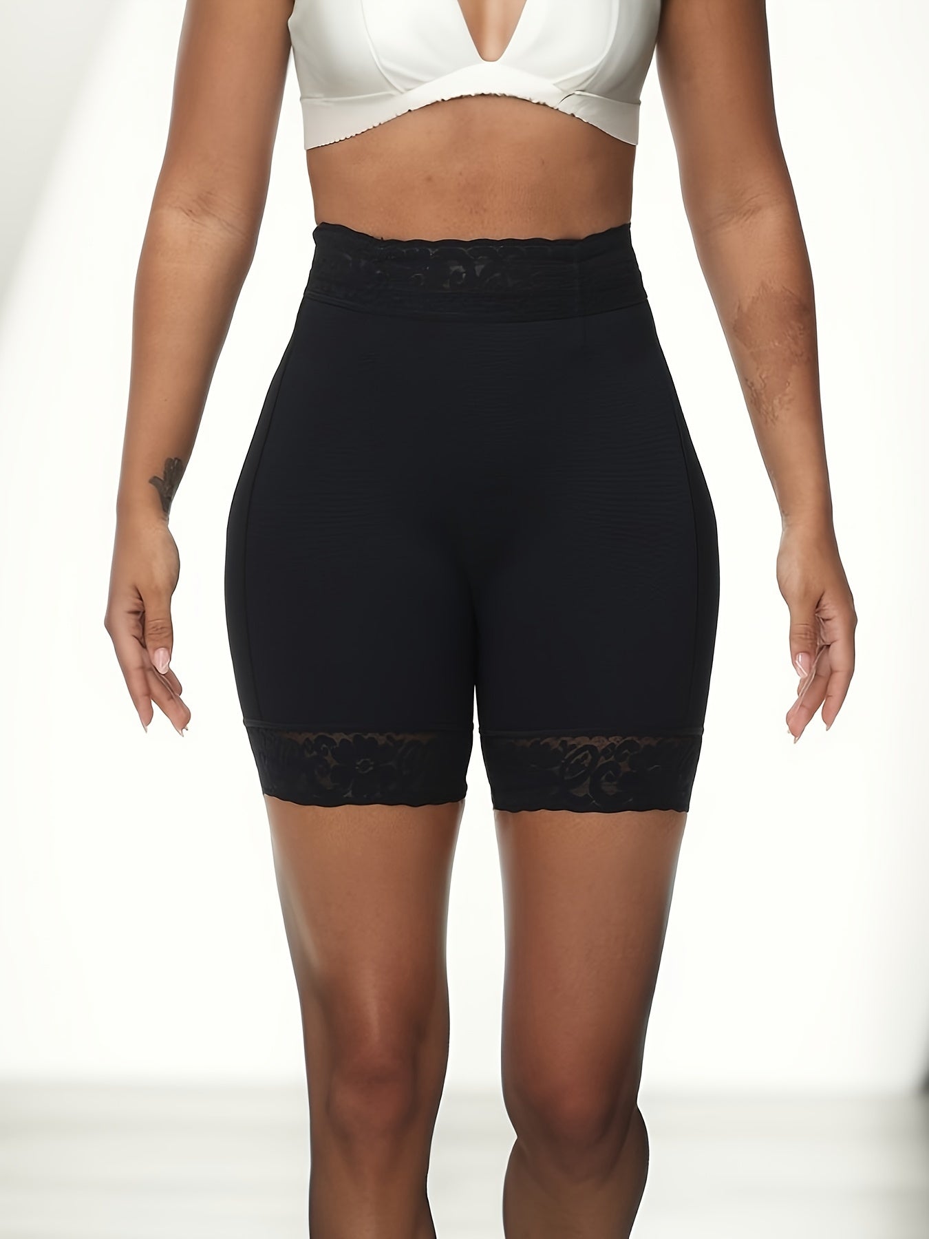 Women's high-waist shaping shorts with lace trim, tummy control, and butt lifting. Made from a breathable nylon/elastane blend with a seamless body sculpting design and floral lace detail.