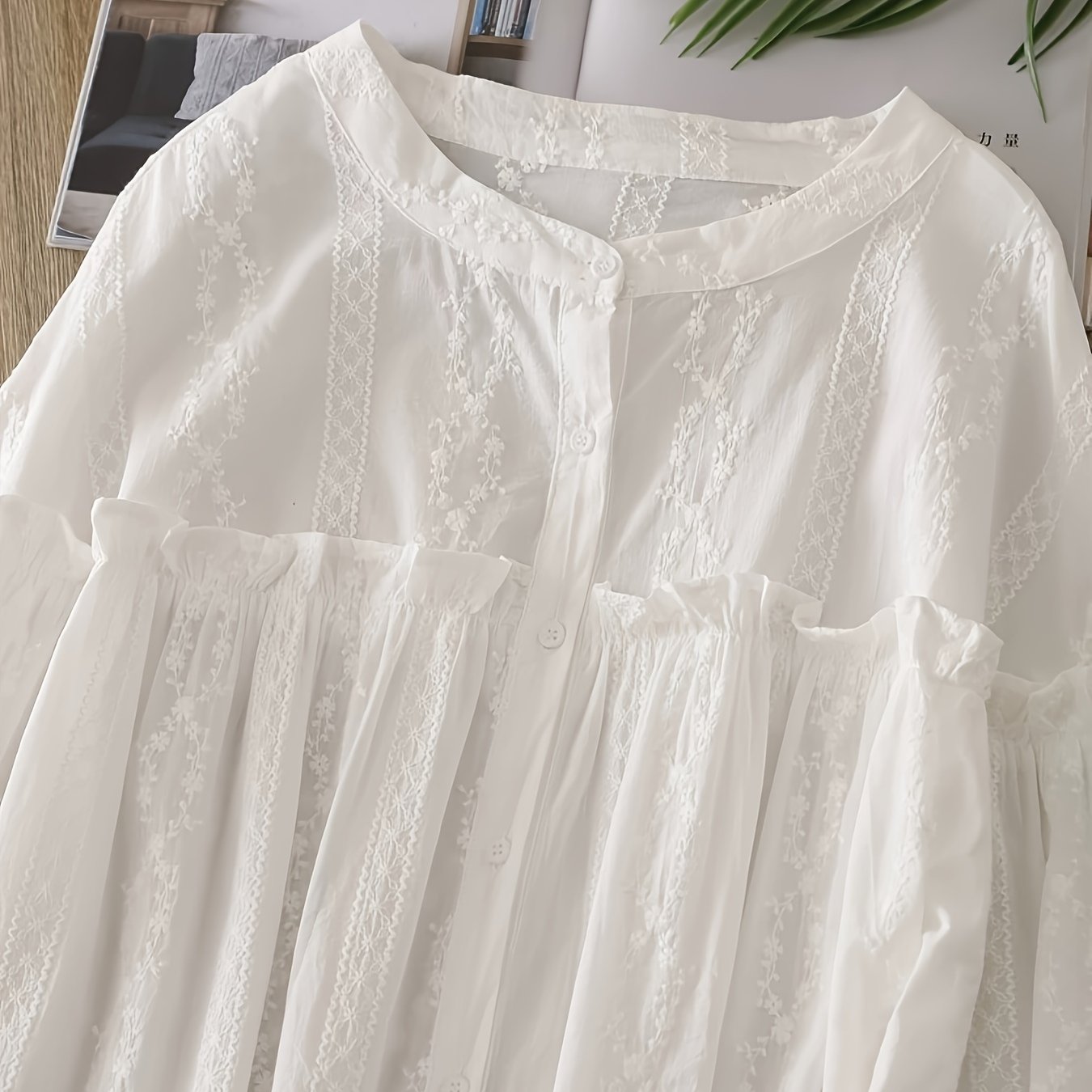 Lace-trimmed long sleeve blouse with ruffled collar, loose fit, and semi-sheer design. Button-up style in solid white, ideal for casual wear.