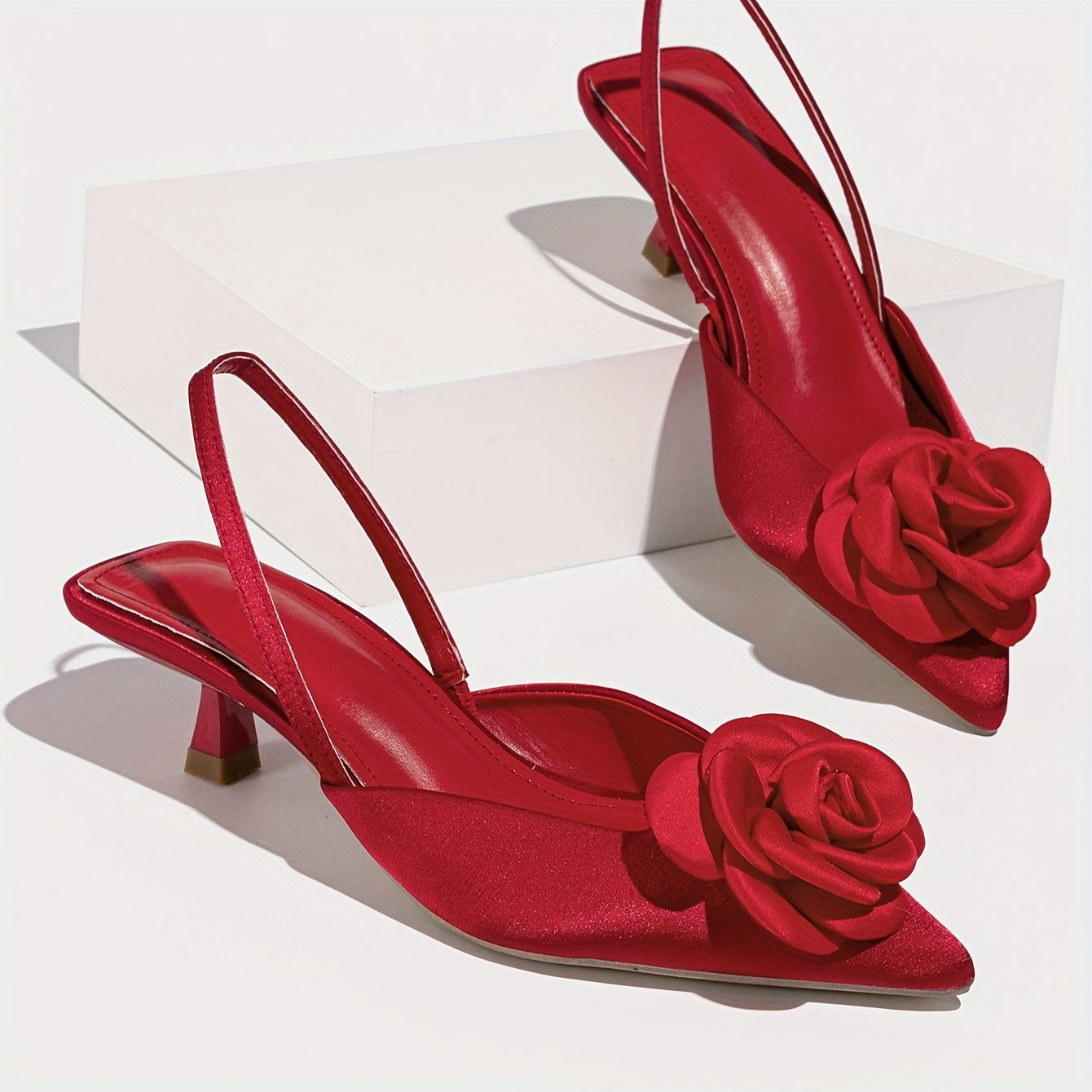 Pointed red high heel shoes with three-dimensional flowers, perfect for night weddings.