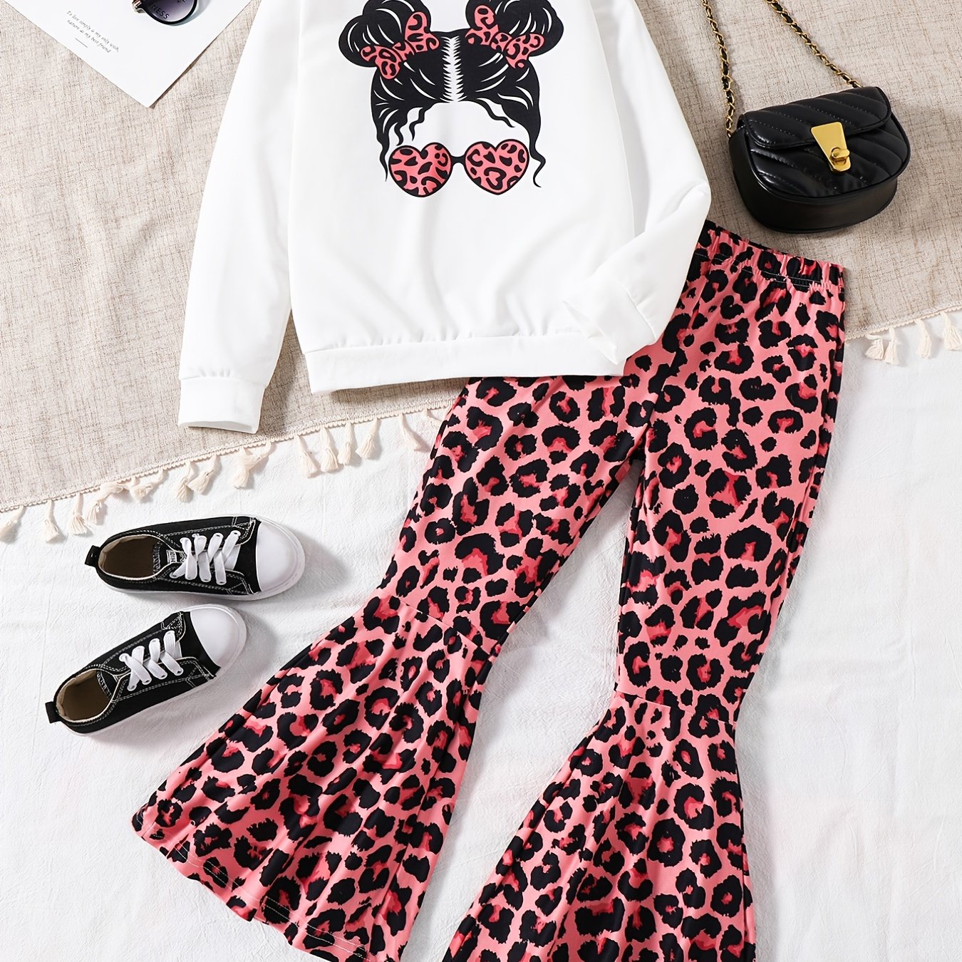 Girls' trendy 2-piece outfit includes a sweatshirt, leopard pattern flared pants, and sunglasses print. Perfect for spring and fall outdoor wear.