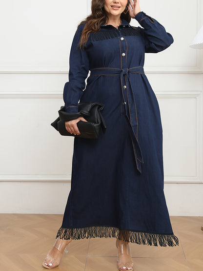 Women's plus size navy blue denim dress with long sleeves, button-up shirt collar, fringe hem, belt detail, and cotton/polyester blend. Machine washable.