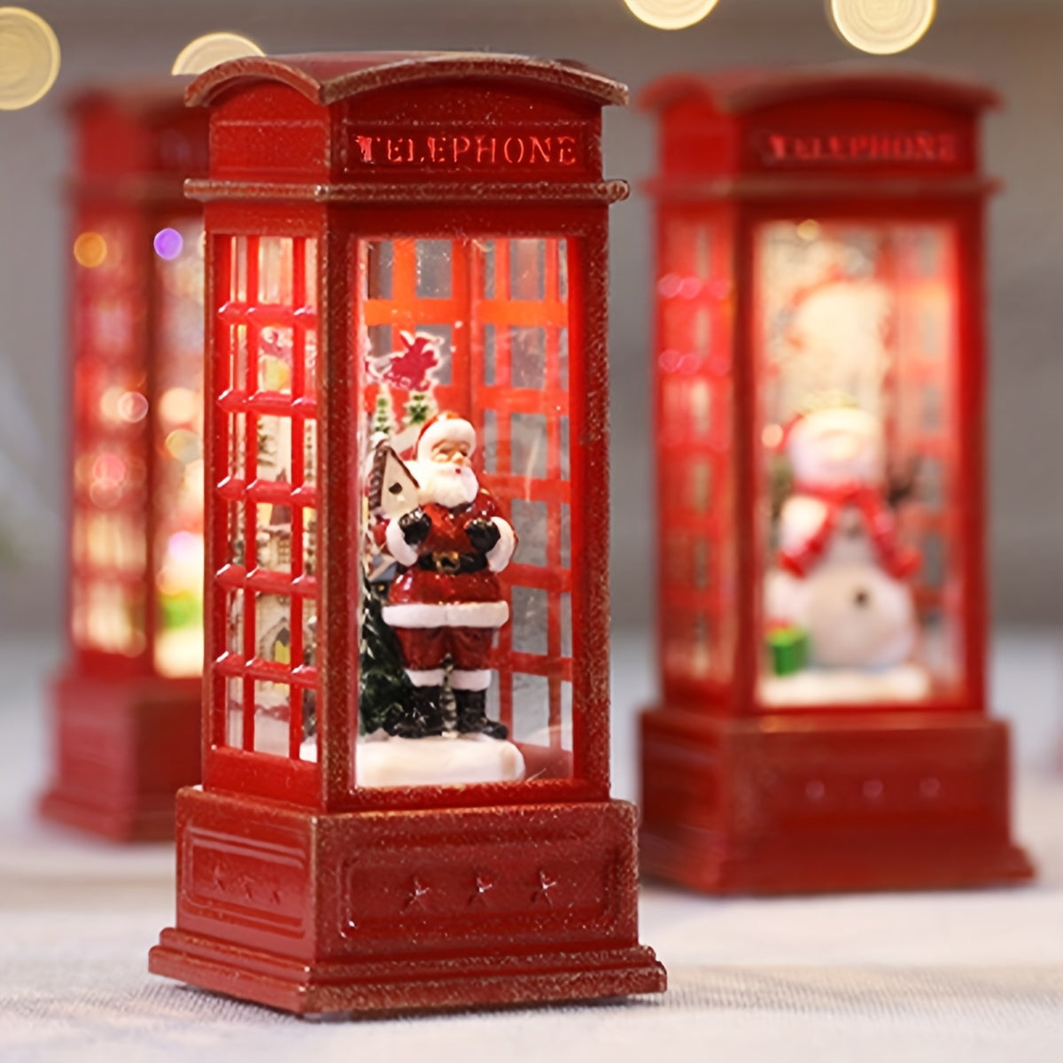 Festive Christmas phone booth decoration featuring Santa, snowman, and tree scenes. Battery-operated with illuminated red cabinet for holiday display.