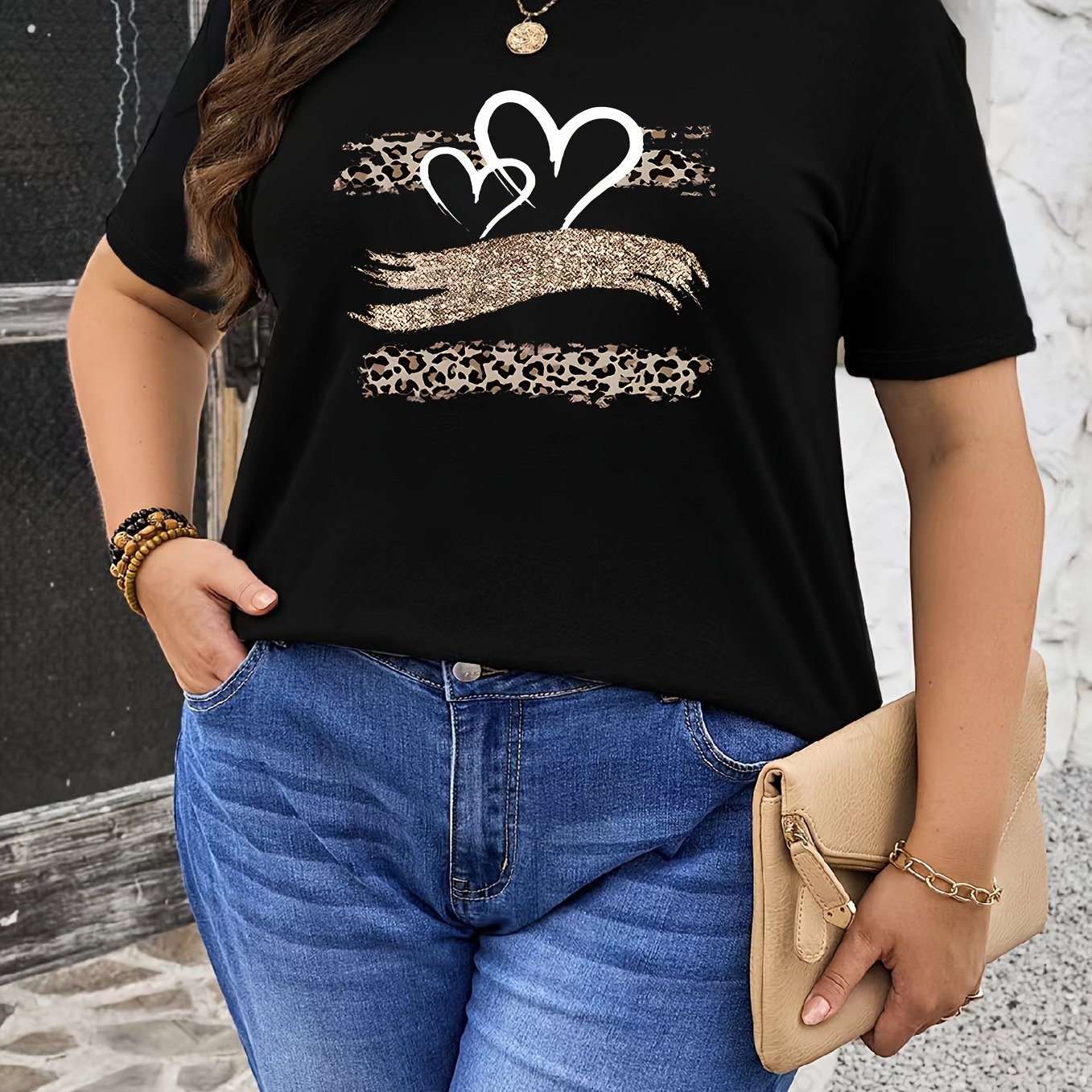 Plus size black T-shirt with leopard and heart print, made of stretchy polyester. Features a round neck, short sleeves, and is suitable for spring and summer wear.