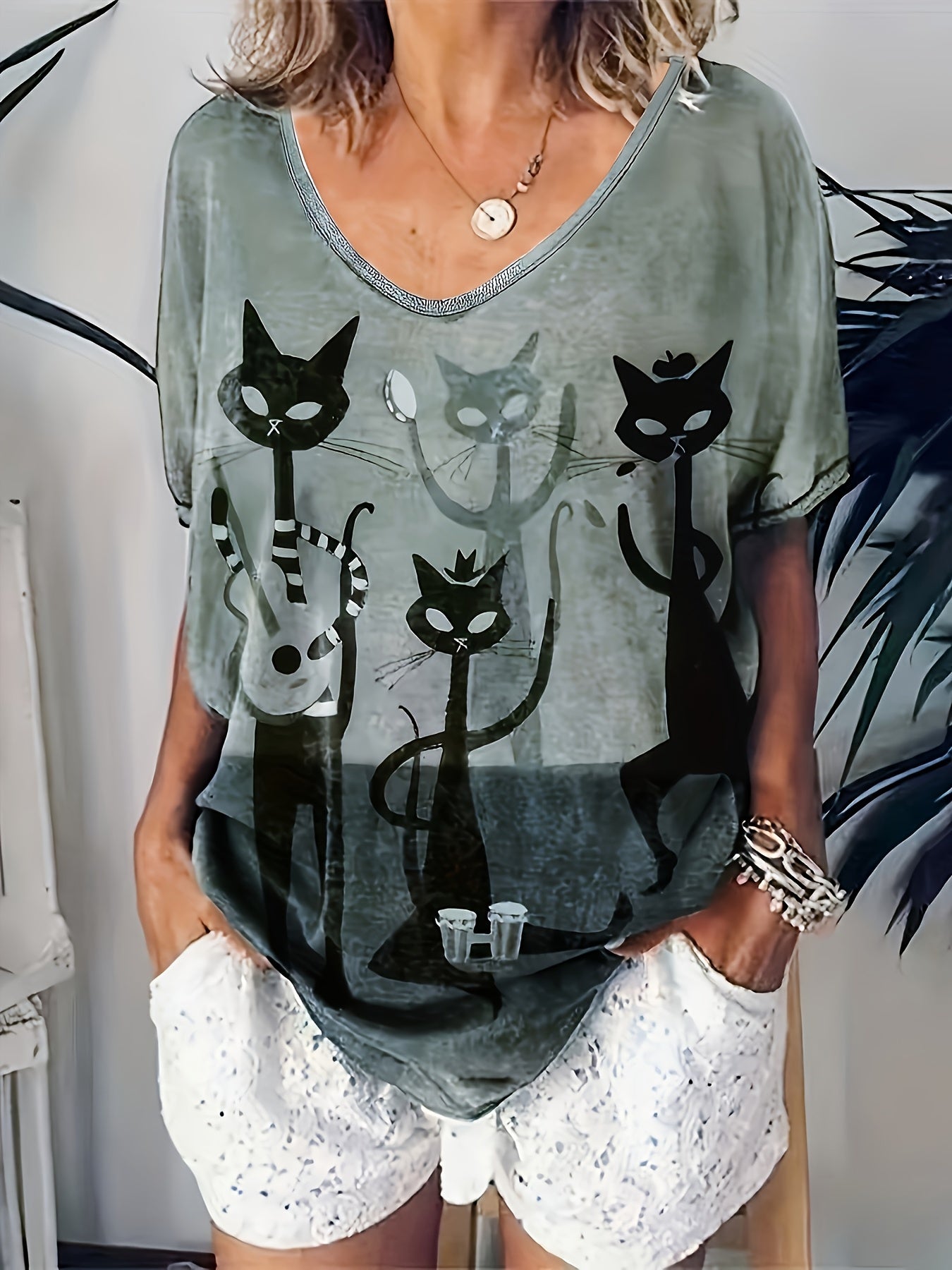 Women's oversized V-neck t-shirt with elegant cartoon cat print, made of 95% polyester and 5% elastane. It has medium stretch, short sleeves, and is made of all-season knit fabric.