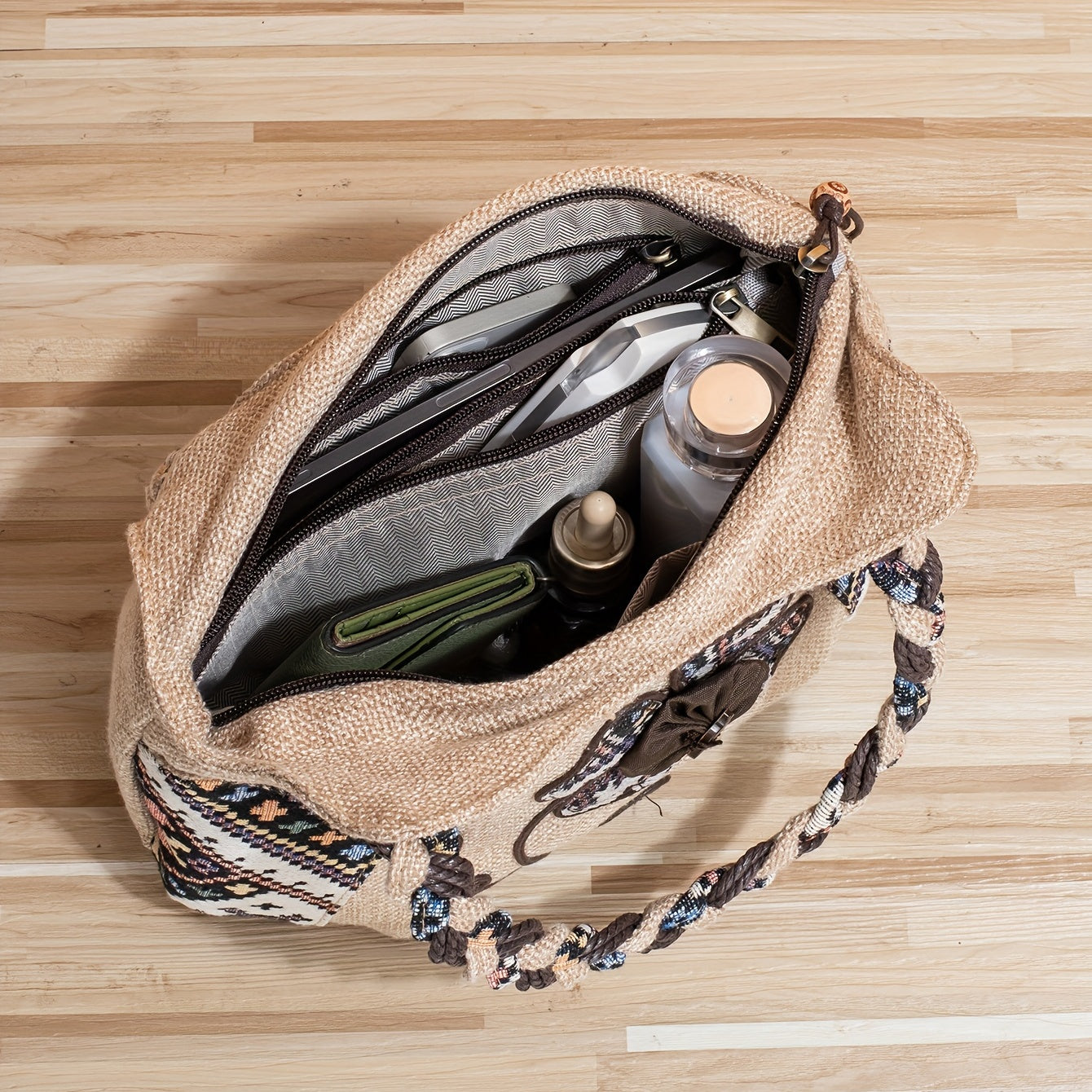 Handmade floral toiletry bag with braided handles, multiple compartments, and zip closure.