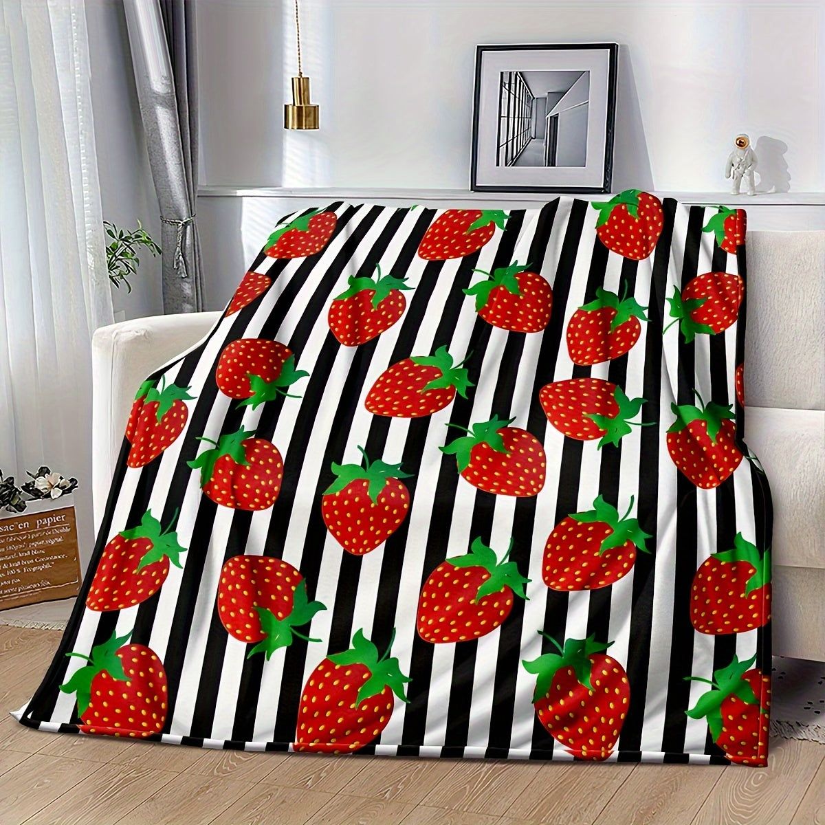 Black striped 1-piece Strawberry Printed Fleece Throw Blanket made from soft microfiber material with a durable twill weave. This all-season blanket features a digital print, is lightweight, and weighs between 250-300g. Perfect for adding a touch of