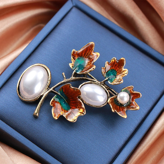 An exquisite vintage plant brooch pin featuring elegant enamel material in an ethnic style. This versatile fashion accessory is perfect for women, ideal for adding a touch of charm to cardigans and jackets.