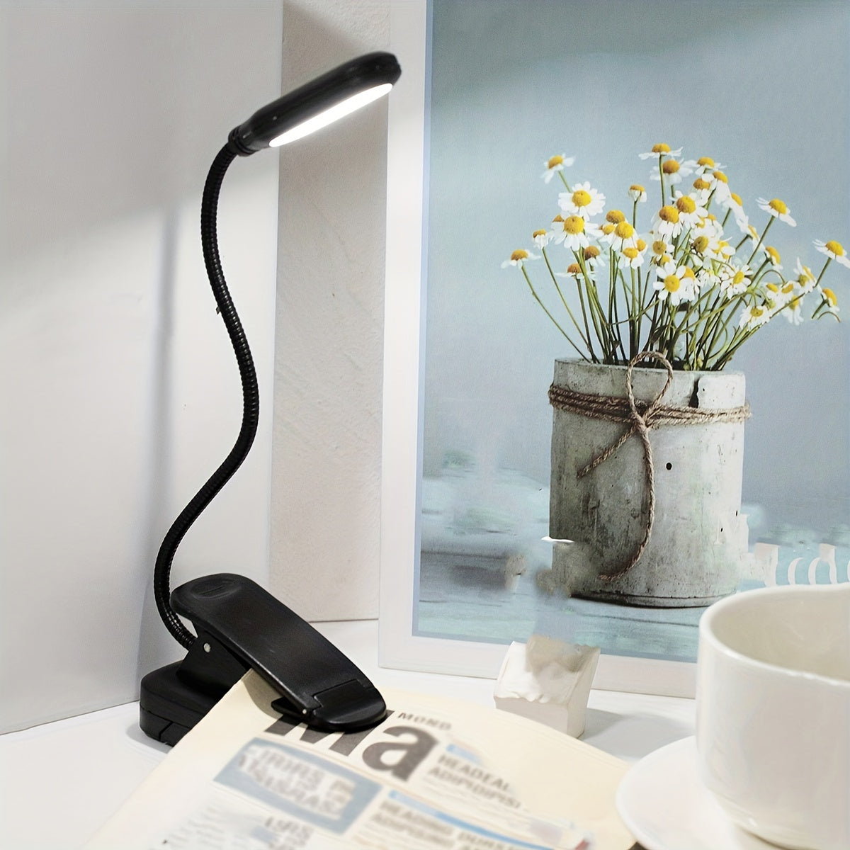 Portable battery-powered clip-on book light with a flexible hose, ideal for reading in small spaces or as a bedside night light.