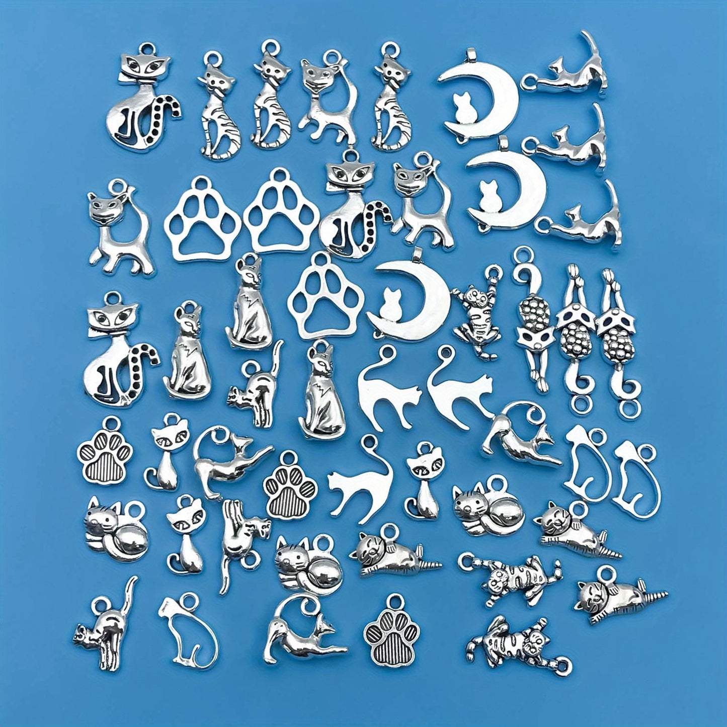 Create your own unique jewelry pieces with this set of 51 zinc alloy antique silvery animal series cat-shaped charms pendants. Perfect for DIY necklaces, bracelets, and earrings.