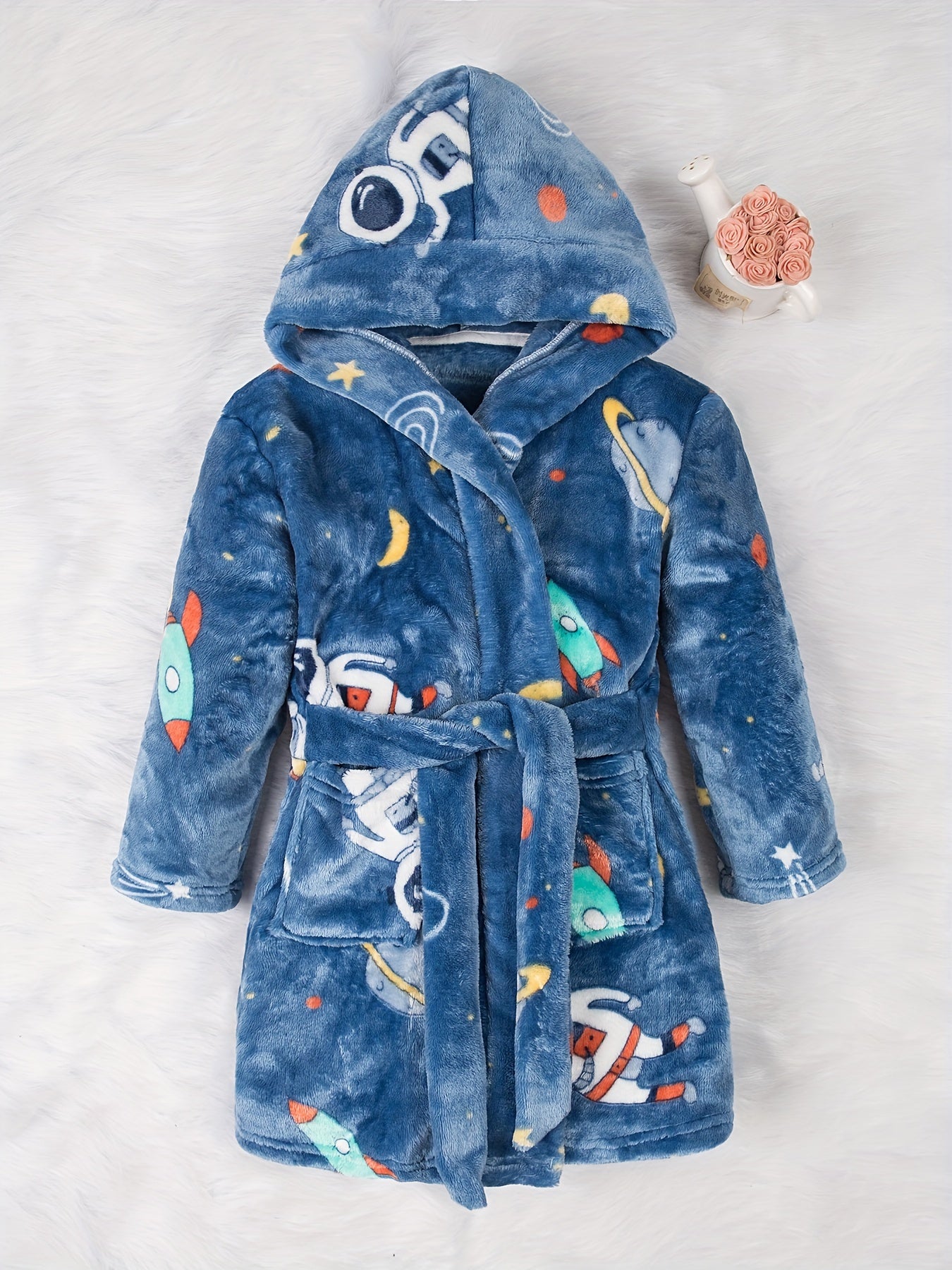 Soft and cozy space-themed boys' fleece robe with flame retardant technology. Features long sleeves, hood, pockets, and is machine washable. Ideal for home and party wear, perfect gift for