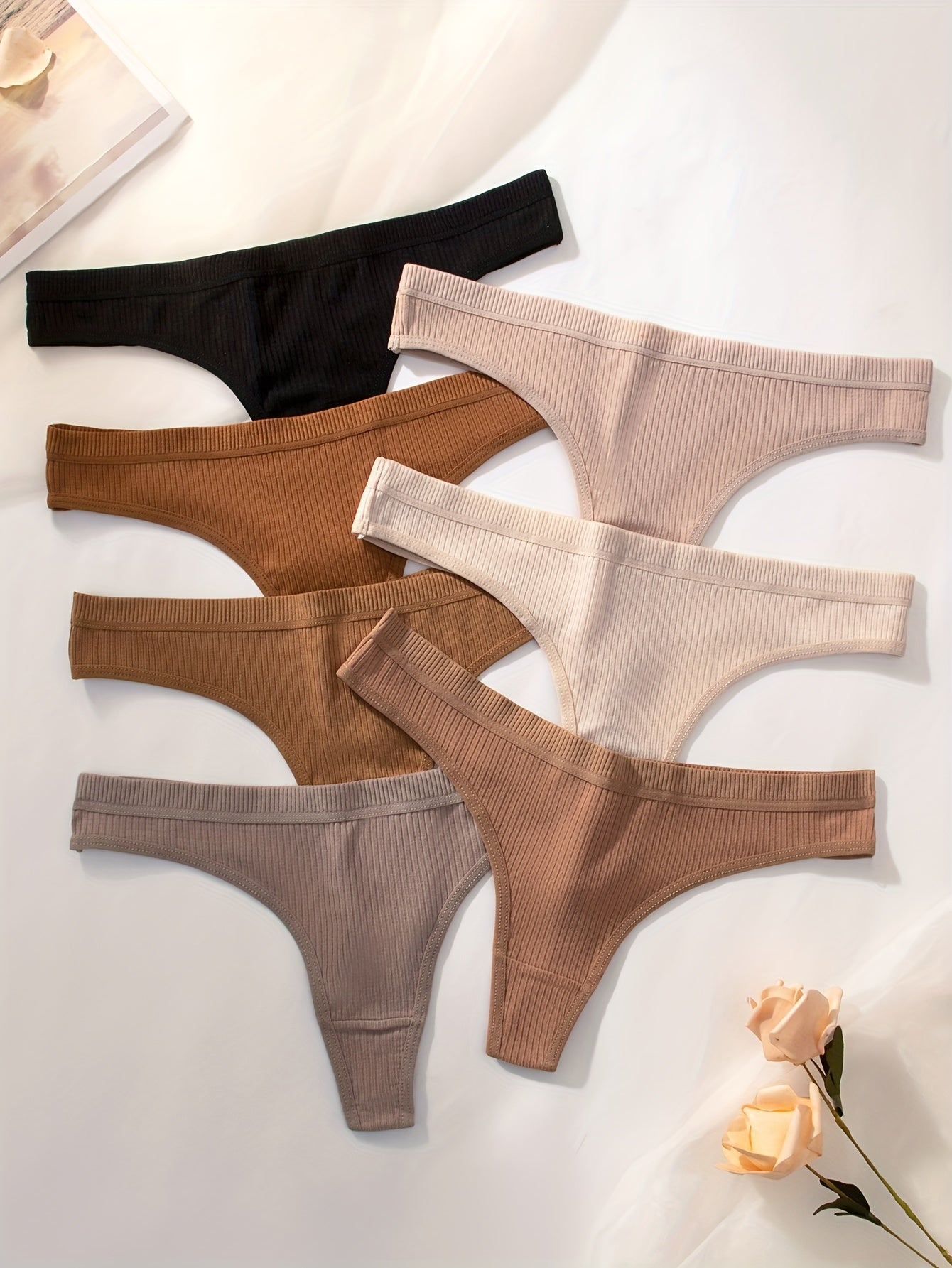 7-pack of women's ribbed thongs in solid colors, made of soft, stretchy polyester blend. Non-see-through, great for casual wear.