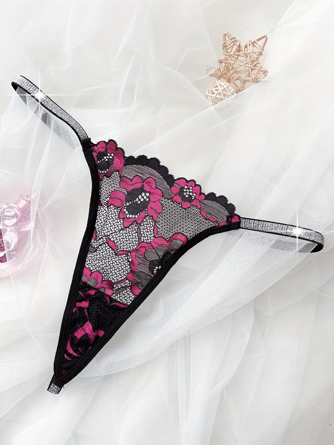 Floral lace thong with shimmering detail, hand washable and made of elastane fabric.