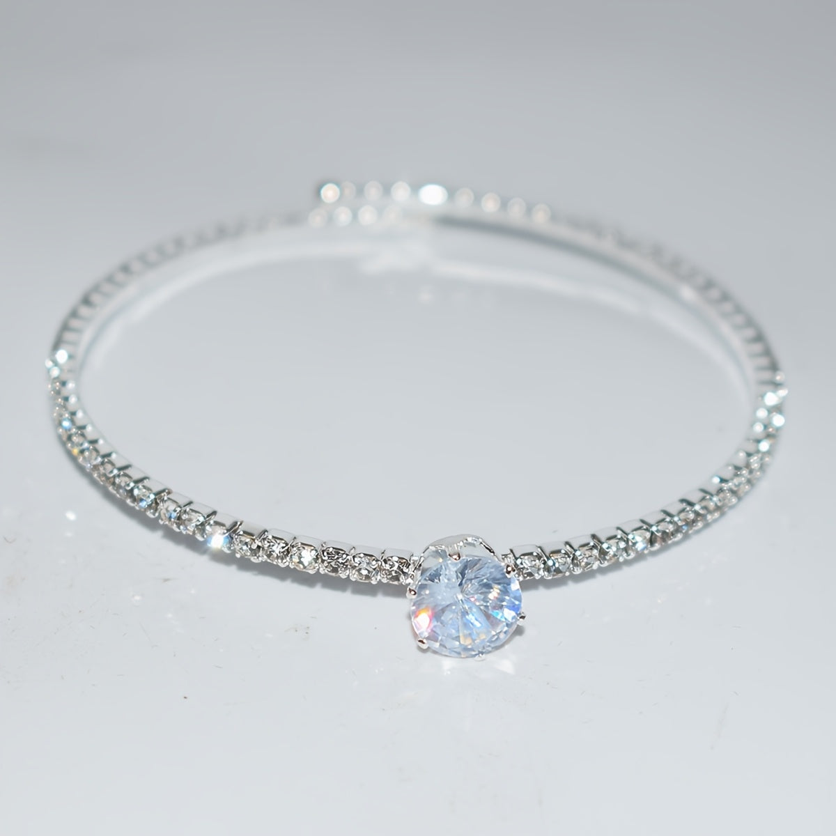 Elegant silvery-plated bracelet with cubic zirconia in classic single row design for weddings and everyday glam.