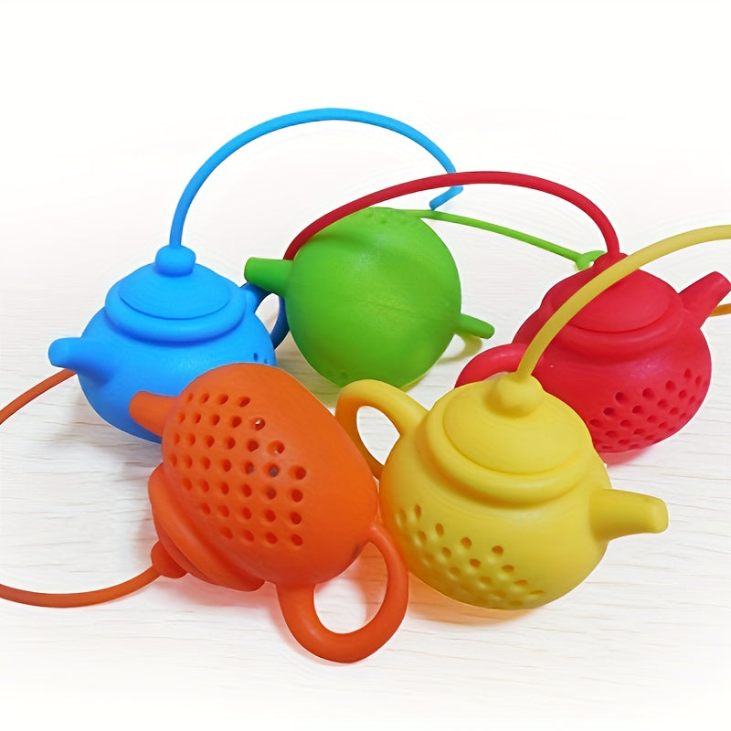 Reusable teapot-shaped tea infuser made of silicone for loose leaf tea, ideal for kitchen and dining use, small in size suitable for making tea.