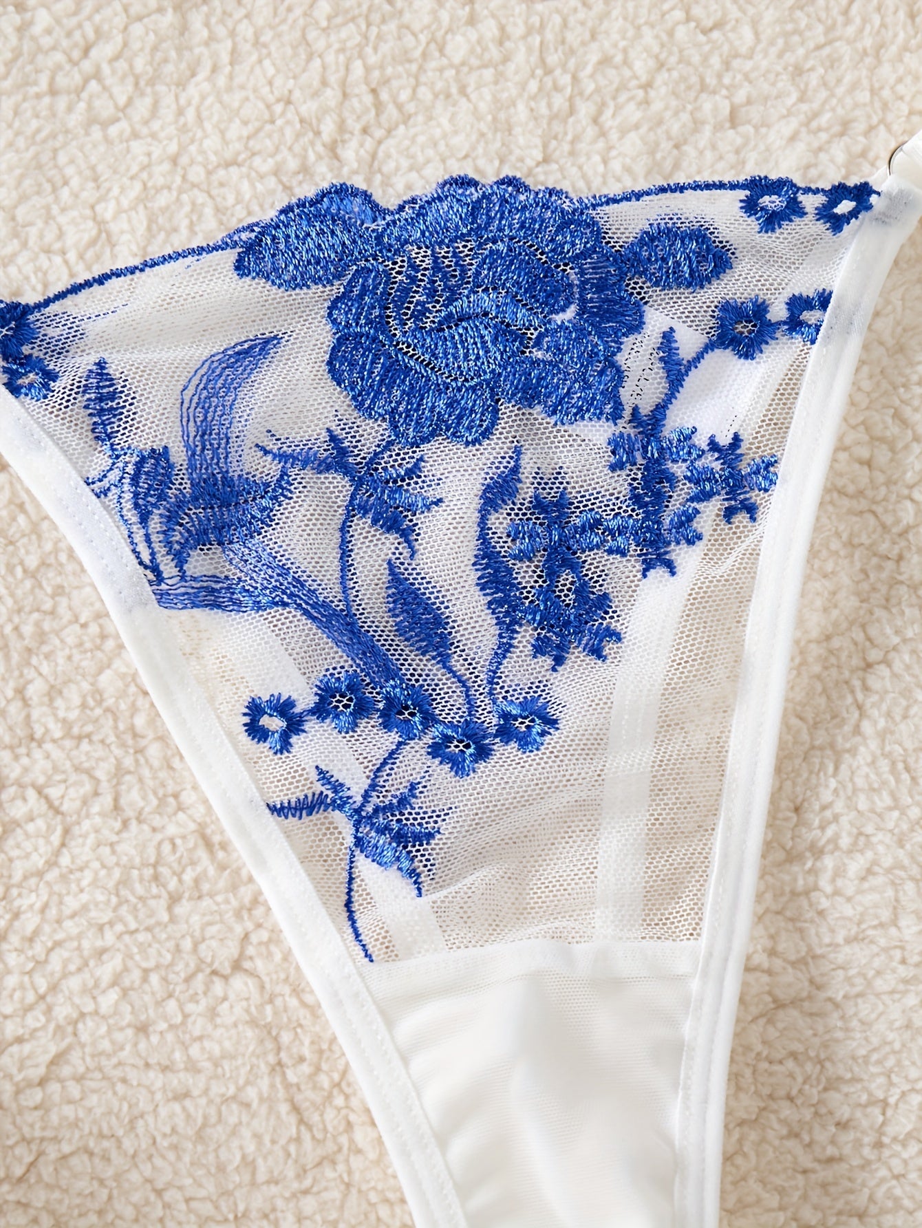 Blue floral embroidered lingerie set with medium support bra and matching thong. Perfect for parties, drop waist style in knit fabric.