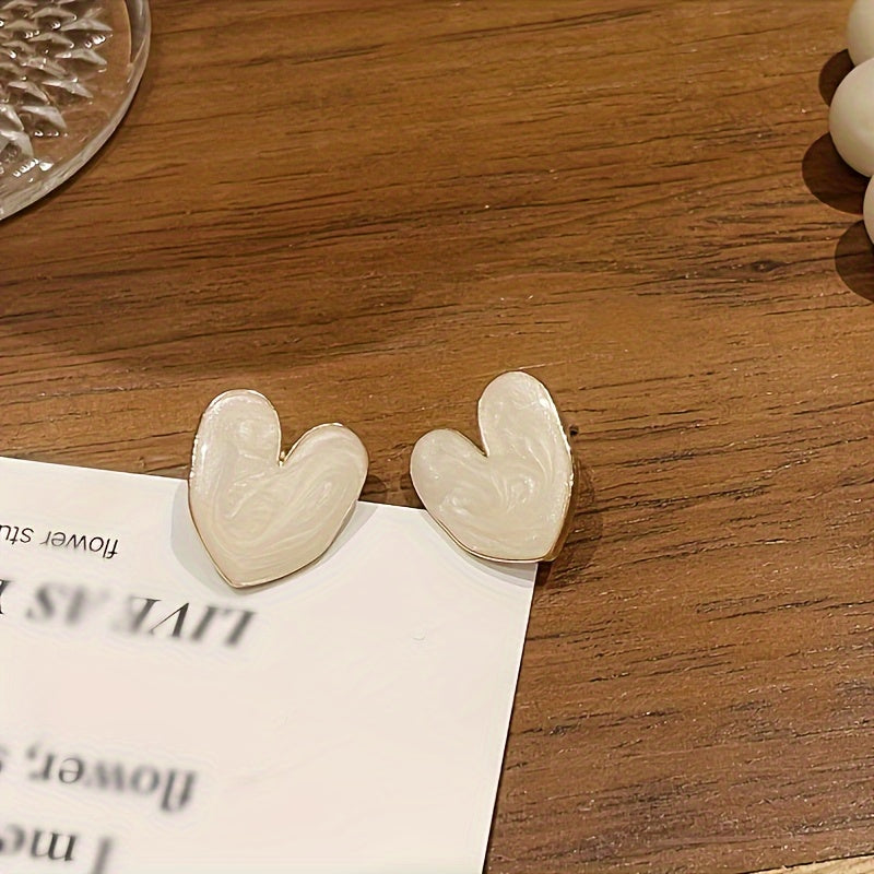 White enamel heart-shaped stud earrings with 925 sterling silver post for everyday and special occasions.