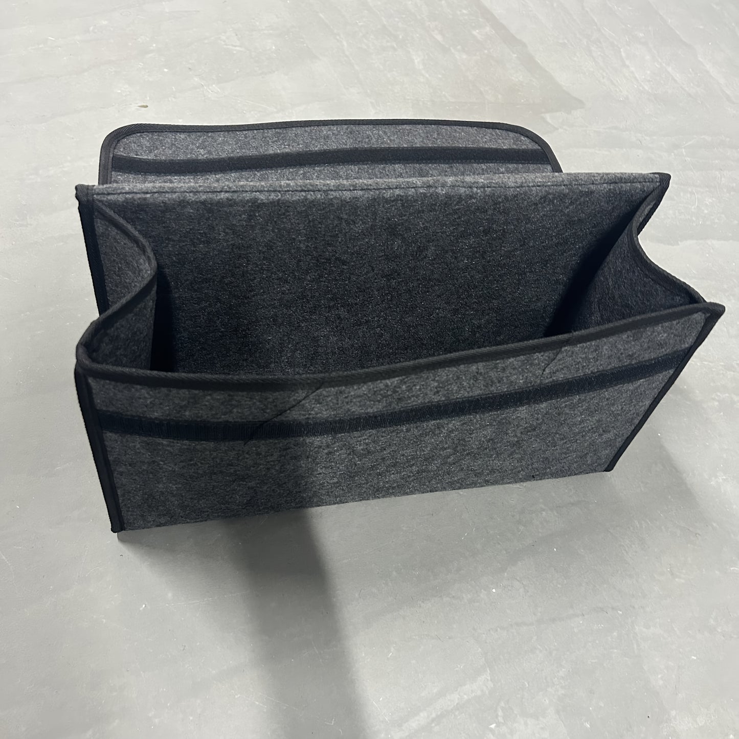 Portable foldable car organizer made of felt cloth for universal fit and interior stowing in vehicles.