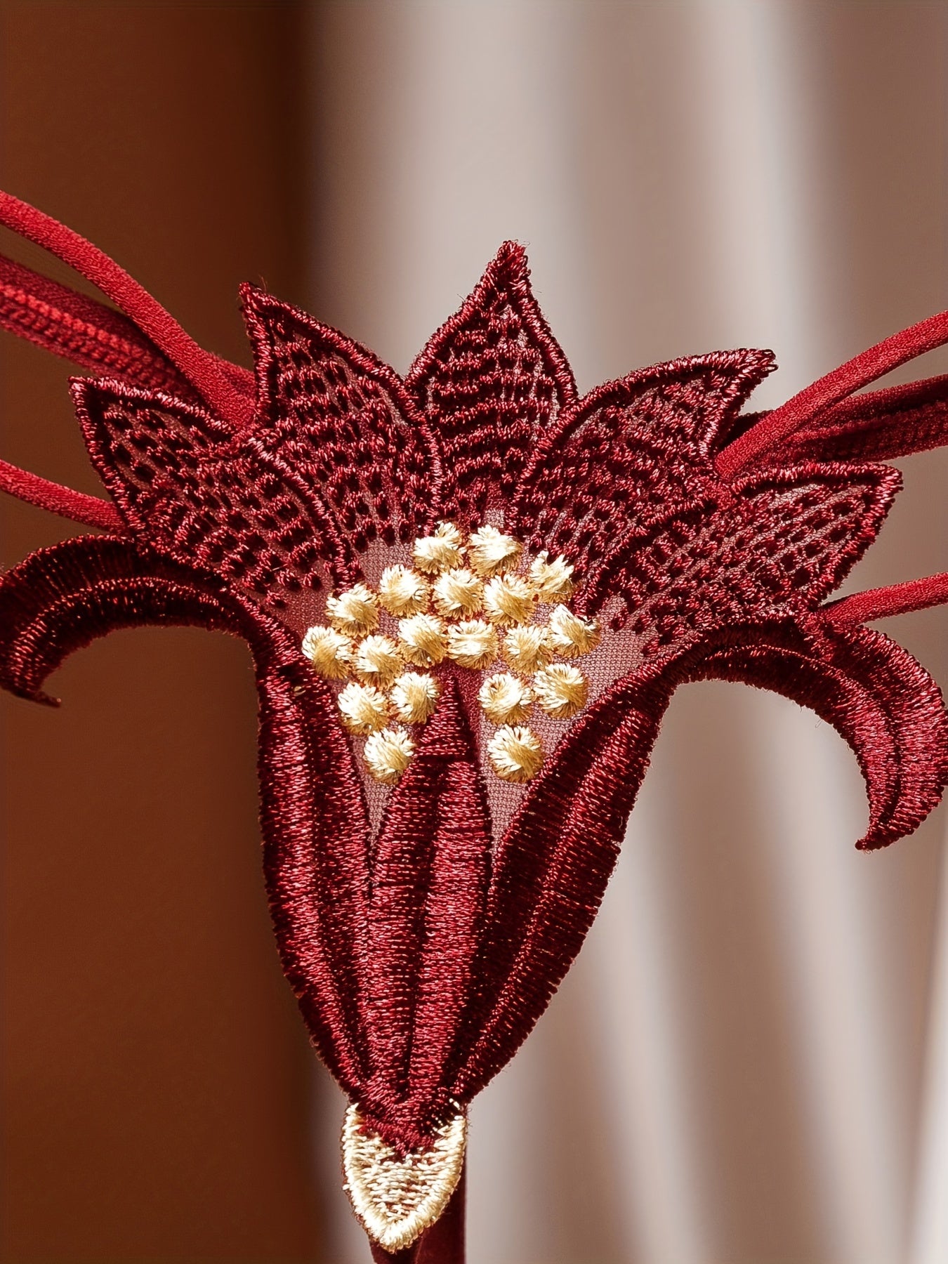 Red lace bodice with pearl details and matching low-rise G-string featuring crochet flowers and beaded embellishments.