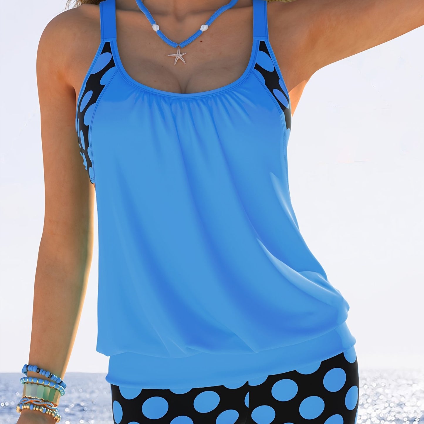 Yellow and black polka dot tankini set for women made of stretchy polyester/elastane blend. Includes round neck top with ruched design and high-waisted shorts. Machine washable. Ideal for