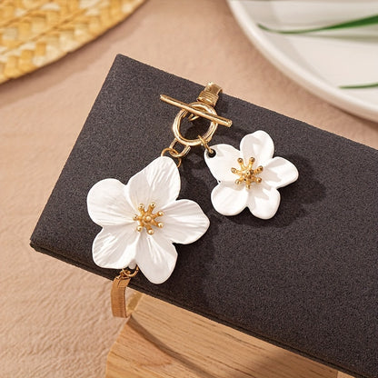 Stylish gold-tone anklet with white flower charms, perfect for vacations and everyday wear.