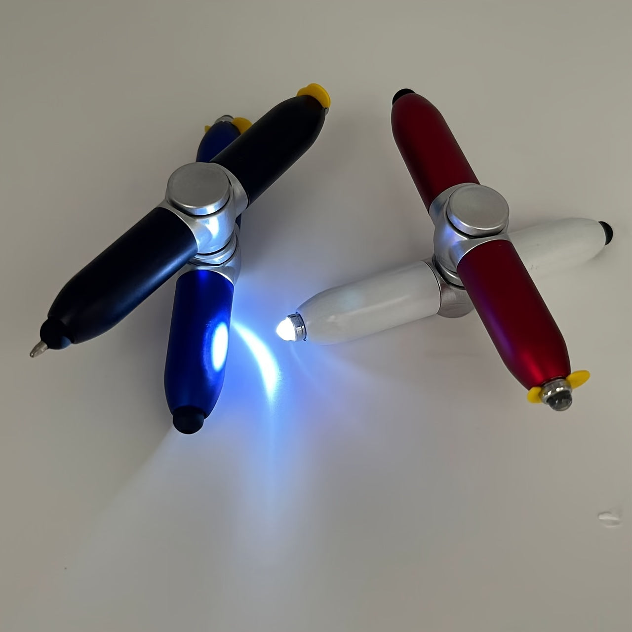 Fidget spinner pen with rotating night light, durable plastic body, mixed colors, and multifunctionality.