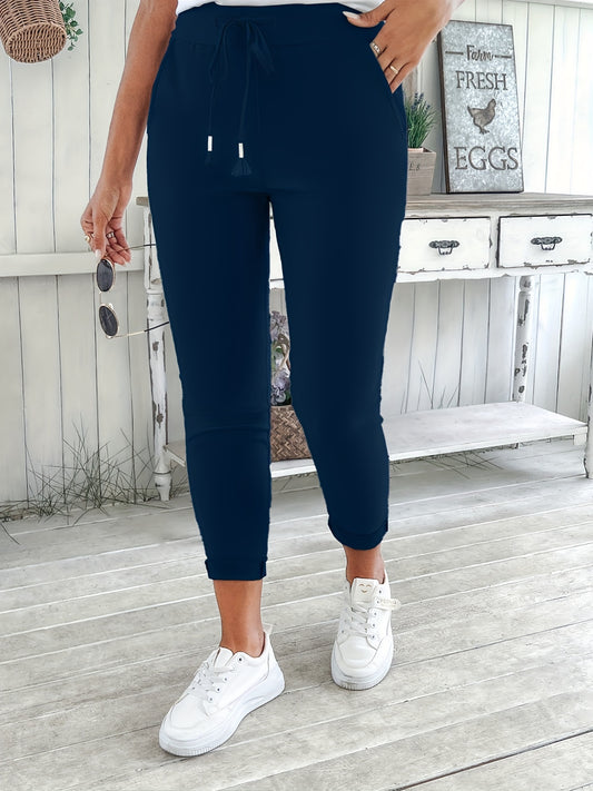 Navy blue drawstring jogger pants for women. Made of stretchy polyester with pockets. Machine washable. Comfortable and adjustable, perfect for all seasons.